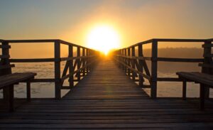 A sunset at the end of a wooden dock